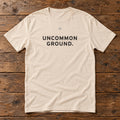 Front of the Uncommon Ground Tee reading UNCOMMON GROUND.
